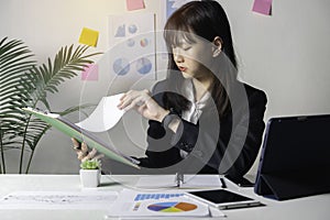 Business woman sitting in her office and checking the company`s earnings