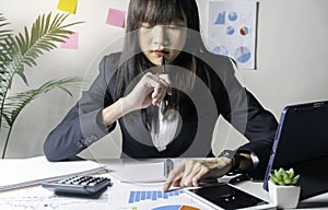 Business woman sitting in her office and checking the company`s earnings