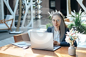 business woman sitting at a laptop in a cafe.