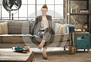 Business woman sitting in loft apartment on couch