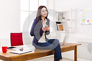 Business woman sitting on wooden desk at office