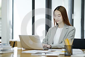 Business woman sitting working on her notebook with confidence and happiness doing a great job