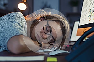 Business woman sleeping on computer at night