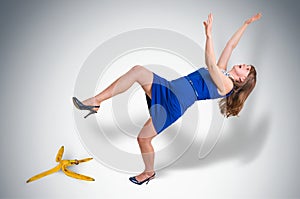 Business woman slipping and falling from a banana peel