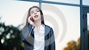 Business woman with smartphone close up near office building. Girl have conversation with cell phone. Beautiful