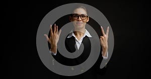 Business woman smiles at the camera and shows the number seven with her fingers