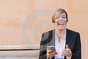 Business woman smiling with a mobile phone on hand