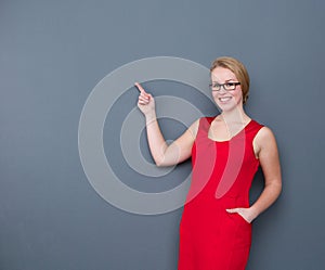 Business woman smiling and pointing to copy space