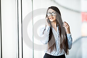 Business woman speak phone in office hall .