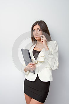 Business woman speaks on mobile with notebook