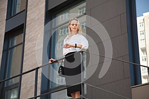 Business woman standing in front of office building