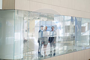 Business woman standing with her staff in background at modern office