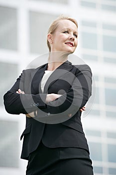 Business woman standing outside office building with arms crossed