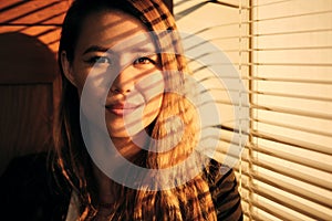 Business Woman Standing By Window With Venetian Blinds