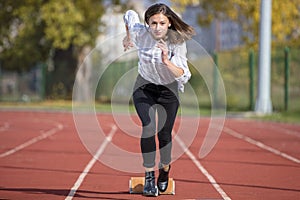 Business woman in start position ready to run and sprint on athletics racing track