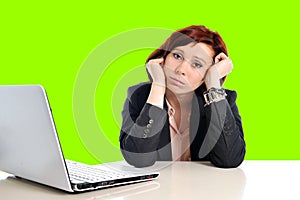 Business woman in stress at work with computer pulling her red hair isolated on green screen chroma croma