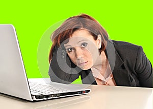 Business woman in stress at work with computer pulling her red hair isolated on green screen chroma croma
