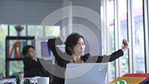 Business woman is stretching after a long working on a laptop computer in office.