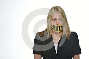 Business woman in studio - caution tape over mouth