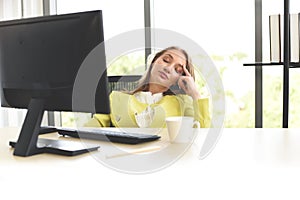 Business woman suffering stress working computer and a cup of coffee on the table / Stressed woman tired with headache at office