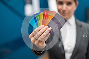 Business woman in a suit holds many different credit cards.