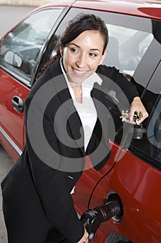Business Woman In Suit Refueling Her Red Car