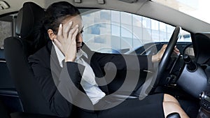 Business woman in suit sitting in auto, feeling sick and tired, pms symptoms