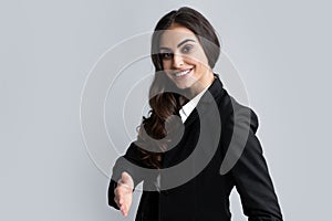 Business woman in suit smiling friendly offering handshake as greeting and welcoming. Businesswoman giving a handshake