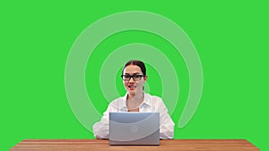 Business woman talking on camera presenting something and closing laptop in the end on a Green Screen, Chroma Key.