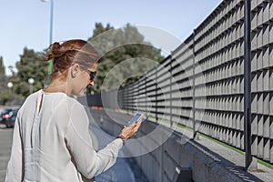 Business woman talking on her mobile phone, while walking down the street