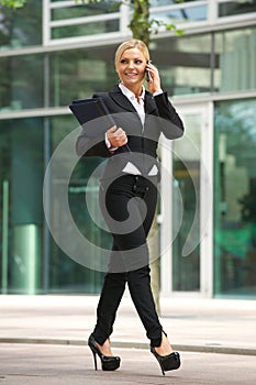 Business woman talking on mobile phone outside the office