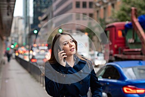 Business woman talking on mobile walking down city street. Half length photo. Germany, Frankfurt