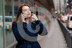 Business woman talking on mobile walking down city street. Half length photo. Germany, Frankfurt