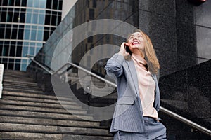 Business woman talking on the phone in the background of an office building