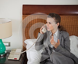 Business woman talking phone in hotel room