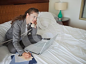 Business woman talking phone in hotel room