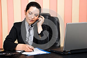 Business woman talking by phone and write on paper