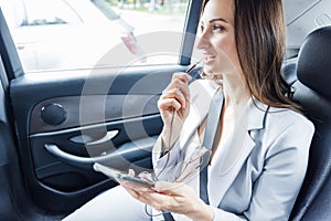 business woman in taxi using her phone