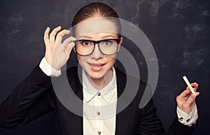 Business woman teacher with glasses and a suit with chalk at a