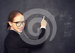 Business woman teacher with glasses and a suit with chalk