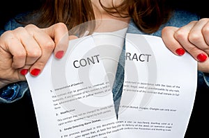 Business woman tearing contract - isolated on black