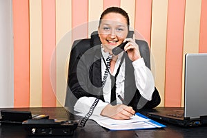 Business woman by telephone taking notes