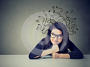 Business woman thinking contemplating a solution sitting at table