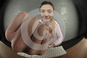 Business woman threatens with fist, blurred background