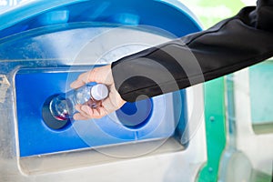 Business woman throwing empty glass bottle water into recycle garbage trash