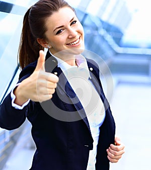 Business woman with thumbs up looking happy