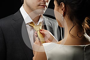 Business woman ties a necktie to a businessman