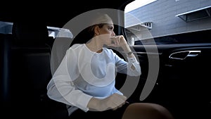 Business woman tired of hustle and bustle of big city looking in vehicle window