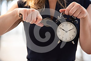 Business woman try to adjust time on alarm clock after shocked with late in rush hours when going to work in city urban background