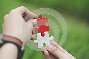 Business woman is trying to connect couple puzzle piece. Symbol of association and connection. Concept of business strategy